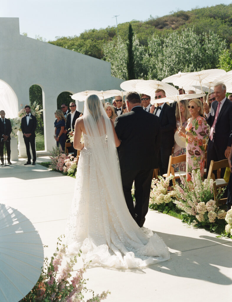 Bride walking down the aisle with her father at Jeune Perché wedding ceremony in Fallbrook, California